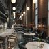 The Winery Hotel, Solna lounge with long communal tables, bar, and hanging globe lights