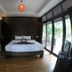 Lipe Sunset Beach Resort room in Ko Lipe with king bed, balcony doors, and wooded view