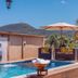 Jardim Do Eden Piri in Pirenópolis with a pool, umbrella-shaded seating, and mountain views