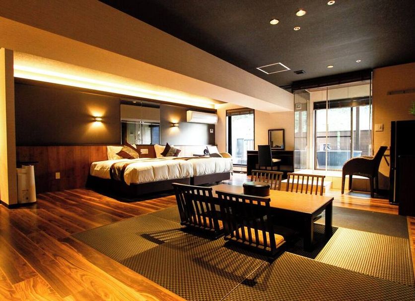 Livemax Resort Aki Miyajima in Hatsukaichi: modern room with bed, seating area and balcony doors