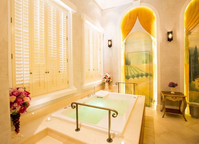 Toscana Town Square Suites in Ban Mo Takhian: bright spa bath with soaking tub and painted arched alcove