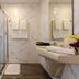 Marina Burgas Hotel bathroom with glass shower, marble-style walls, and wall-mounted sink in Burgas