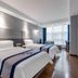 Xiamen Junming Hotel in Xiamen: twin beds, wall-mounted TV and city-view window in a modern guest room