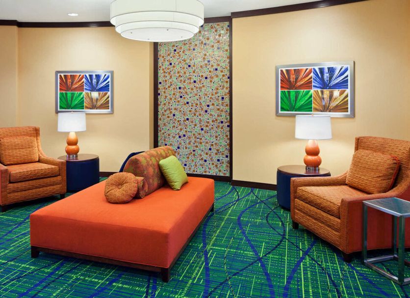 Fairfield Inn & Suites by Marriott Lewisburg lounge with orange seating and colorful patterned carpet