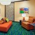 Fairfield Inn & Suites by Marriott Lewisburg lounge with orange seating and colorful patterned carpet