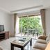 Jomtien Beach Penthouses in Pattaya living room with balcony doors and leafy view