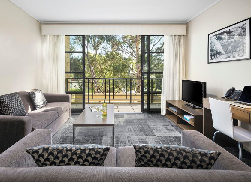 Quest Narre Warren hotel room with balcony view, sofa, desk, and TV in Narre Warren