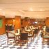 Hotel Maurya International in Chennai lounge with wooden chairs, tables and black-and-white checkered floor