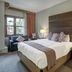 The Osprey at Beaver Creek guest room with king bed, armchair, and mountain-view window