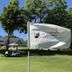 Maxwelton Braes Lodge in Baileys Harbor with golf cart on the green and flag by the lodge