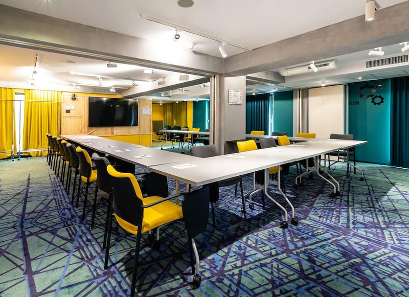 Meeting room at ibis Styles Bucharest Erbas in Bucharest with U-shaped tables and yellow chairs