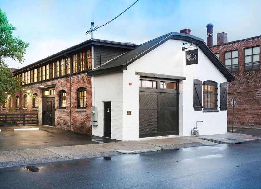 Dye House in Providence, brick-and-white exterior of the hotel building on a wet street