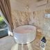EcoResort Il Cantico della Natura in Magione bathroom with round soaking tub, marble walls, and walk-in shower