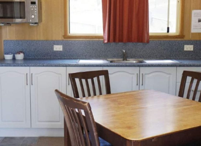 Mount Rumney Escapes - Platypus Cabin kitchen with dining table and chairs in Cambridge