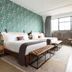 Arrive Memphis guest room with twin beds, patterned accent wall, desk, and large window in Memphis