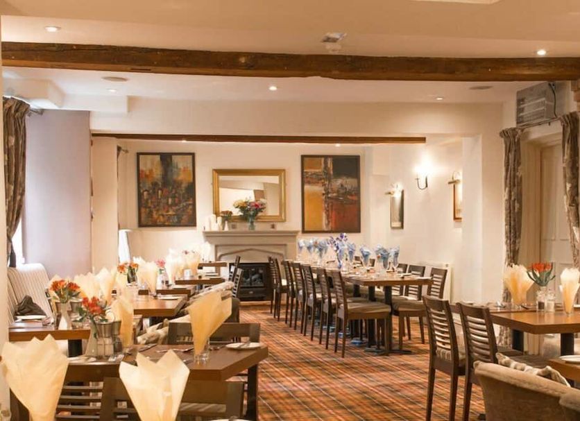 The Greyhound Coaching Inn, Lutterworth: elegant dining room with set tables and plaid carpet