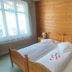 Hotel De La Paix, Interlaken guest room with wooden double bed, bedside tables and window