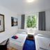 Basement Rotherbaum Hamburg twin room with desk, window view and blue rug