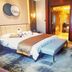 Anyang Huaqiang Nuohuating Hotel in Anyang guest room with king bed, bench, and bathroom doorway