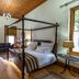 Evergreen Manor and Spa Stellenbosch bedroom with four-poster bed, fireplace and seating area