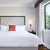 The Abernathy Clemson guest room with king bed, bedside lamps, and large window view