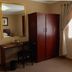 Oak Rest Guesthouse Kimberley room with wardrobe, desk, mirror and window curtains
