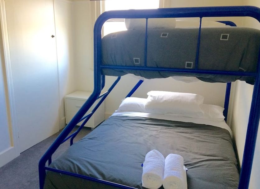 Great Ocean Road Brewhouse Apollo Bay room with blue bunk bed and neatly made single bed