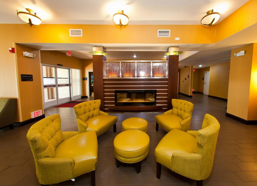 Hampton Inn & Suites Sacramento-Cal Expo lobby seating area with yellow chairs and fireplace in Sacramento