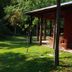 Rio Arriba Suites Apartments y Resto in Bella Vista with a lush garden beside a shaded wooden terrace