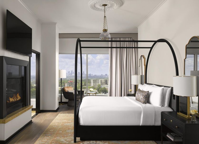 Intercontinental Hotels Buckhead Atlanta guest room with fireplace, canopy bed, and city view