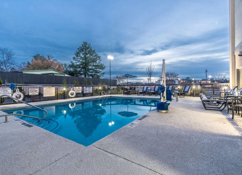 Hampton Inn Milledgeville outdoor pool at dusk with lounge chairs and patio seating