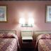 OYO Hotel Kings At Clovis guest room with two patterned beds, wall lamps, and framed art in Clovis