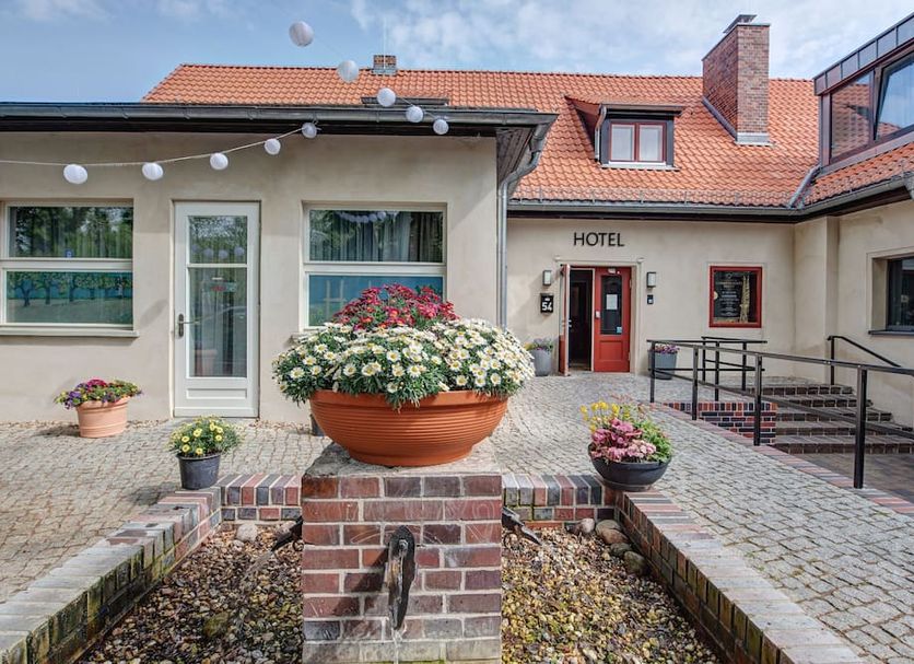 Landhotel Diana in Teltow courtyard entrance with flower planters and red-tiled roof