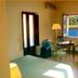 Illicini Maratea guest room with twin beds, table chairs, and window view of the water