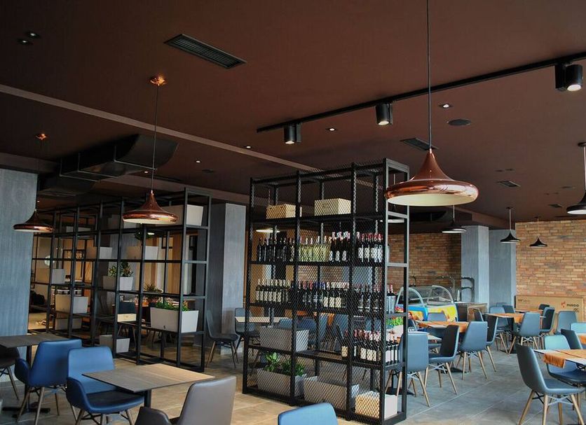 Hotel Frojd - Beach Front Resort dining area with tables, chairs, shelving and brick wall in Shëngjin