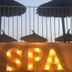 Finca Hotel Rural Es Turó in Ses Salines with lit SPA sign and thatched umbrellas behind a railing