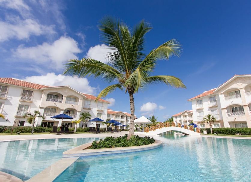 Los Flamencos Aparthotel in San Rafael del Yuma with palm-lined pool and white resort buildings