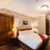 Rokeby Manor in Invergarry bedroom with wooden bed, floral wallpaper, and antique furnishings