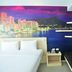 The Aim Patong Hotel room with bed, bench, and wall mural of Patong bay skyline