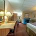 Silver Spruce Inn Glenwood Springs guest room with king bed, desk, lamps, sofa and fireplace