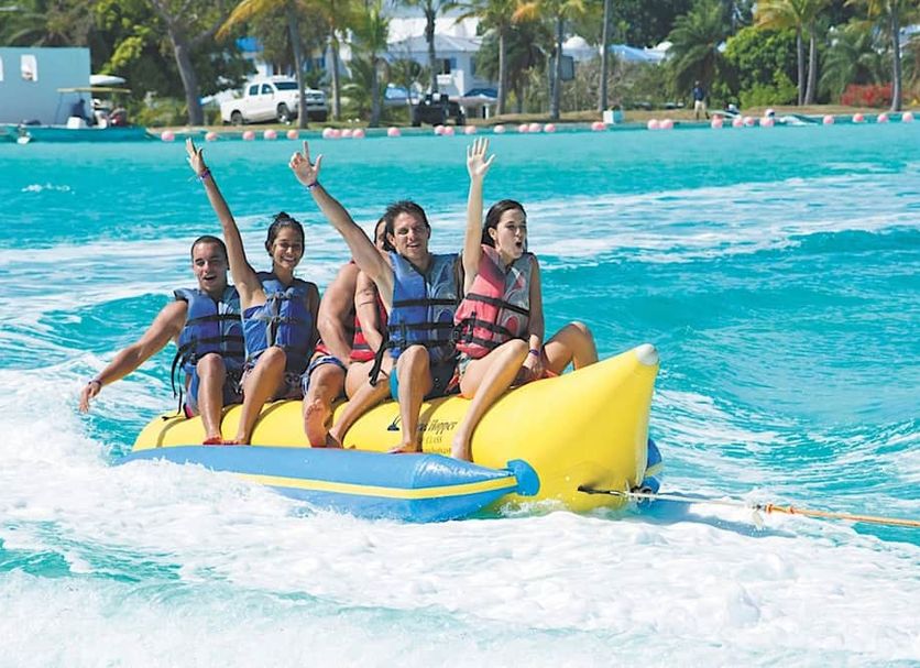 Playa Blanca Beach Resort in Río Hato, guests ride a banana boat on turquoise water