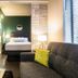 The Oxford at Pike Place Market in Seattle: compact suite with bed, sofa, lamp and window blinds