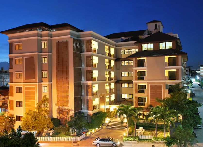 Grand Marina Residence Hotel in Laem Chabang at night, exterior with illuminated balconies and palm trees