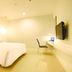 Hotel Glodok Plaza in Jakarta guest room with a bed, wall-mounted TV, desk, and chair