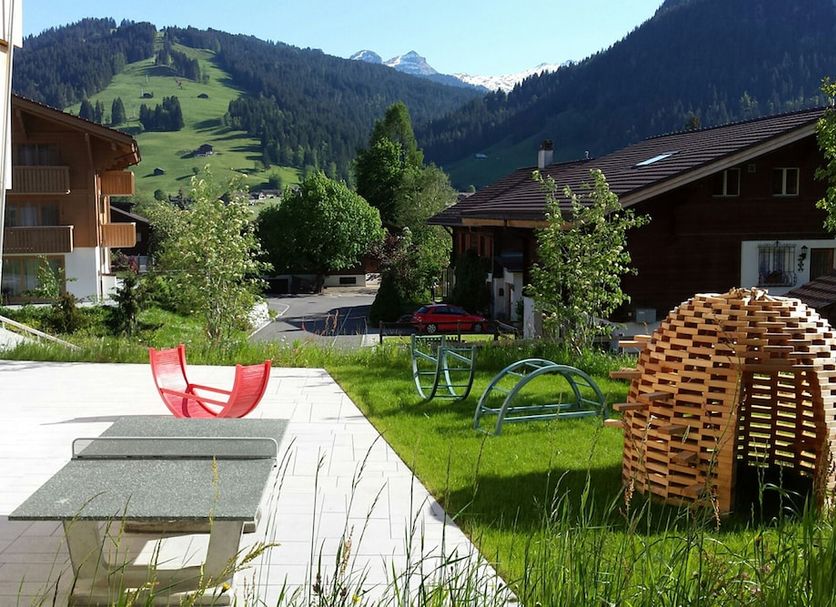 Saanen Gstaad Youth Hostel in Saanen with mountain views, grassy lawn, and outdoor seating