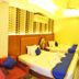 Hotel Grand View in Sylhet guest room with three neatly made beds and patterned wall panels