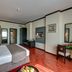 Grandeur Hotel Dubai guest room with king bed, desk, wood floors, and wall-mounted TV