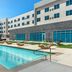 Cambria Hotel Waco University Riverfront pool with lounge chairs and modern exterior in Waco