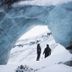 Svalbard Hotell | The Vault in Longyearbyen, snowy ice cave with two people in winter gear