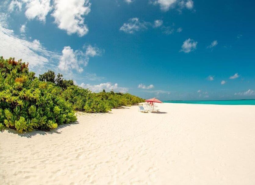 Hondaafushi Island Resort in Hanimaadhoo with white sand beach, turquoise water, and a red umbrella